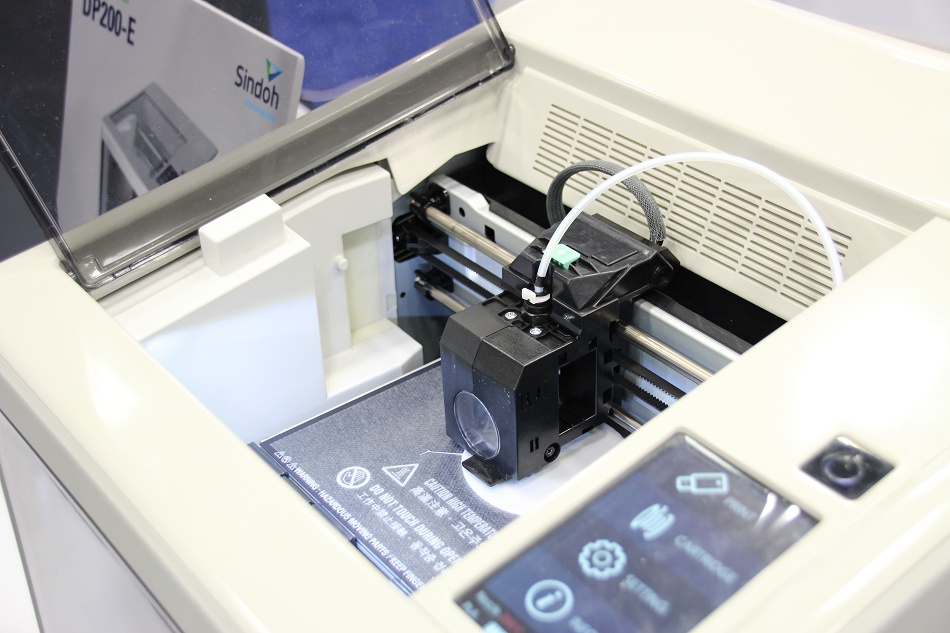 De 3Dwox DP200 printer van Sindoh. LInks de cartridge met het filament erin.